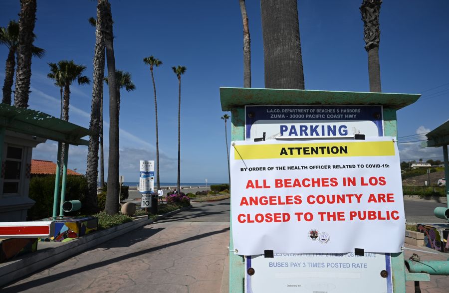 A sign reads that Zuma Beach in Malibu is closed to the public on March 28, 2020, in an effort to stem the growth of COVID-19 cases in Los Angeles County. (ROBYN BECK/AFP via Getty Images)