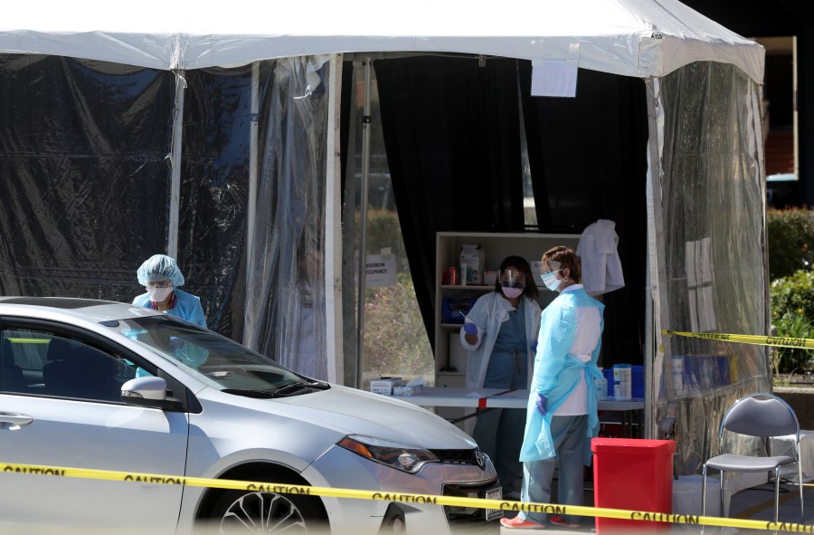 Medical personnel take a sample from a person at a drive-thru coronavirus COVID-19 testing station at a Kaiser Permanente facility on March 12, 2020, in San Francisco, California. (Justin Sullivan/Getty Images)