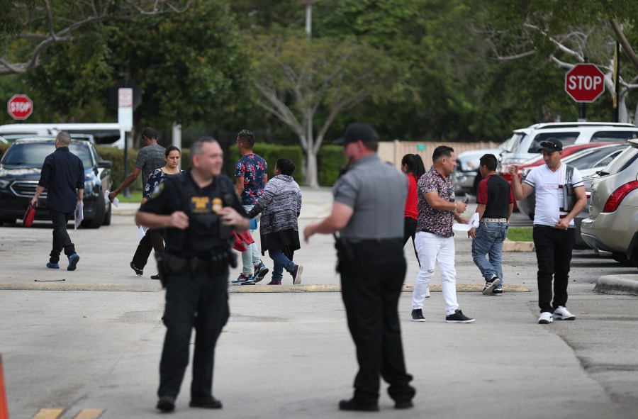 People walk through the parking lot outside the U.S. Immigration and Customs Enforcement office in Miramar, Florida, on March 13, 2020. (Credit: Joe Raedle / Getty Images)