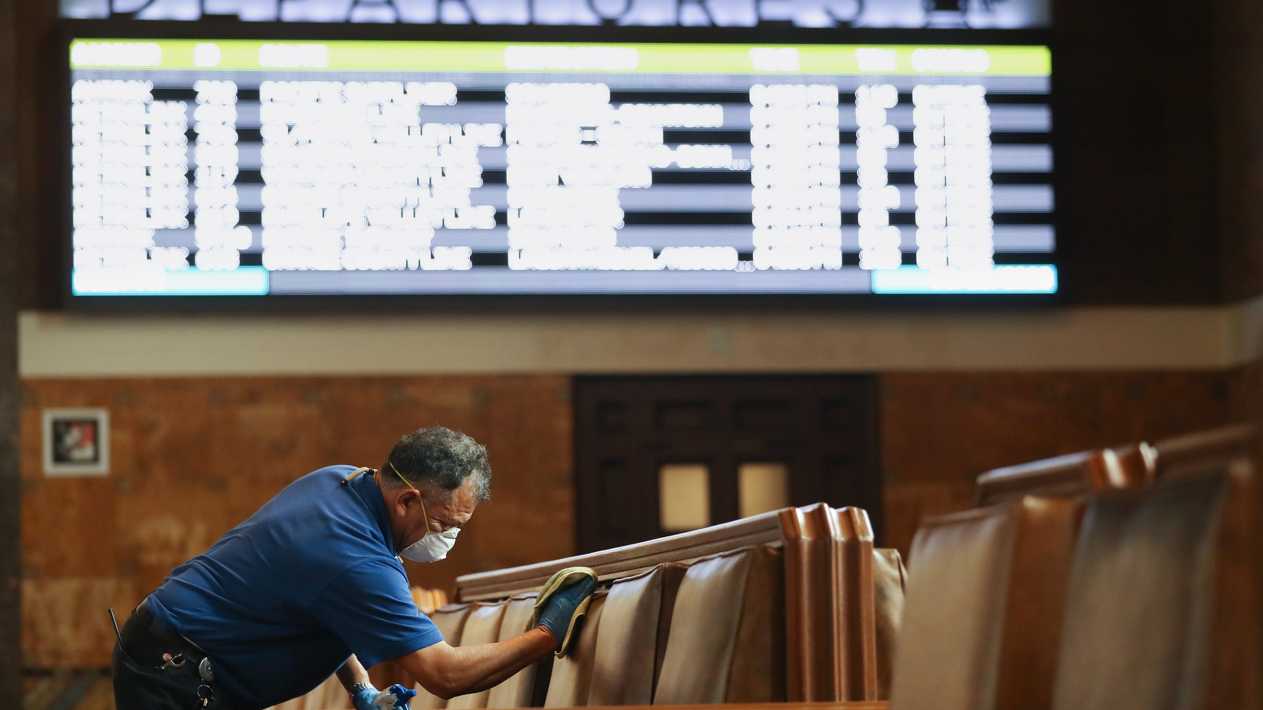 An employee cleans seats in a waiting area at Union Station on March 13, 2020, in Los Angeles.(Mario Tama/Getty Images)