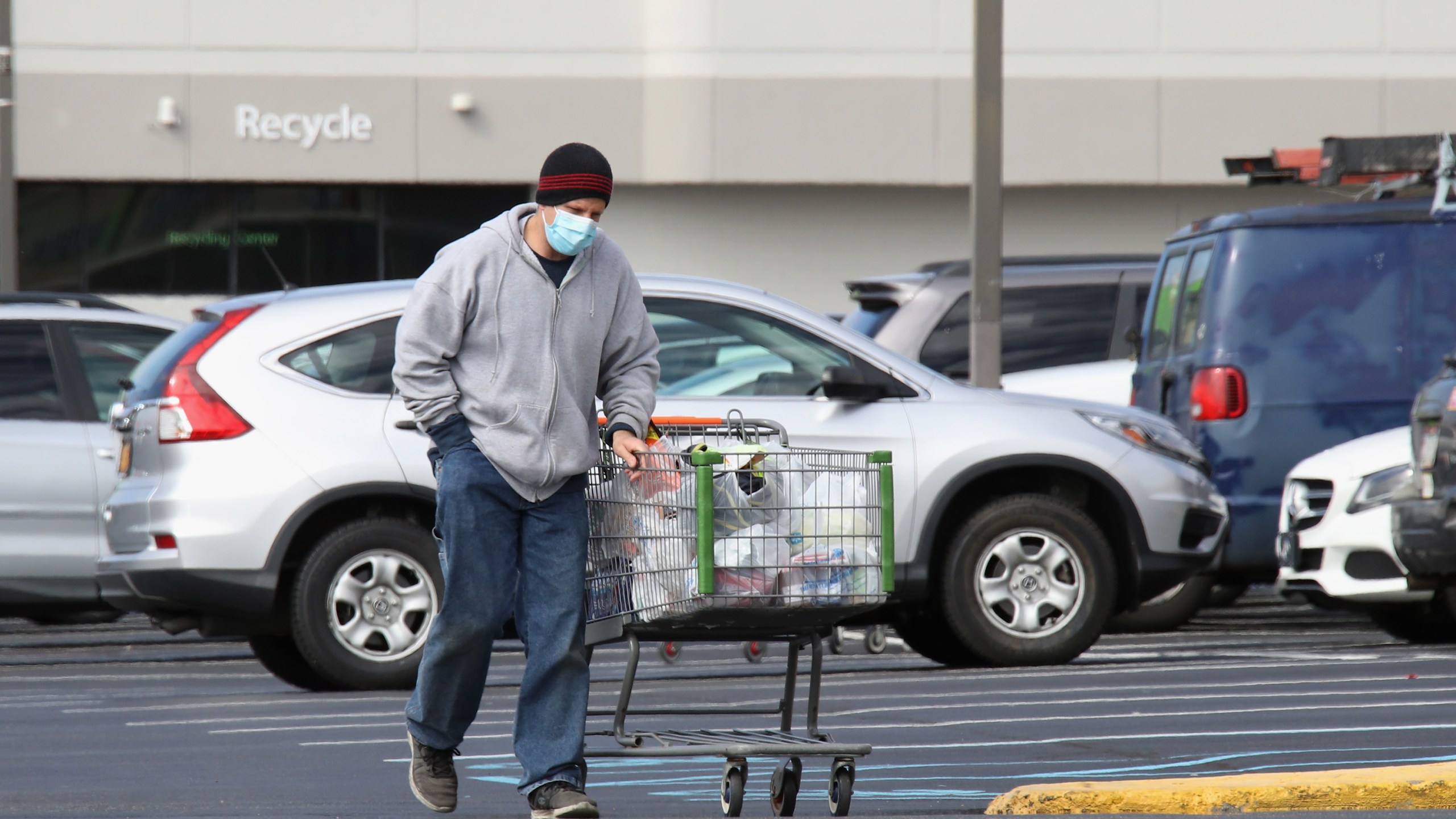 A shopper wearing a face mask returns to his car with goods from a Walmart Neighborhood Market as the coronavirus continues to spread across the United States on March 16, 2020 in Levittown, New York. (Bruce Bennett/Getty Images)