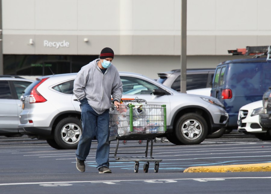 A shopper wearing a face mask returns to his car with goods from a Walmart Neighborhood Market as the coronavirus continues to spread across the United States on March 16, 2020 in Levittown, New York. (Bruce Bennett/Getty Images)