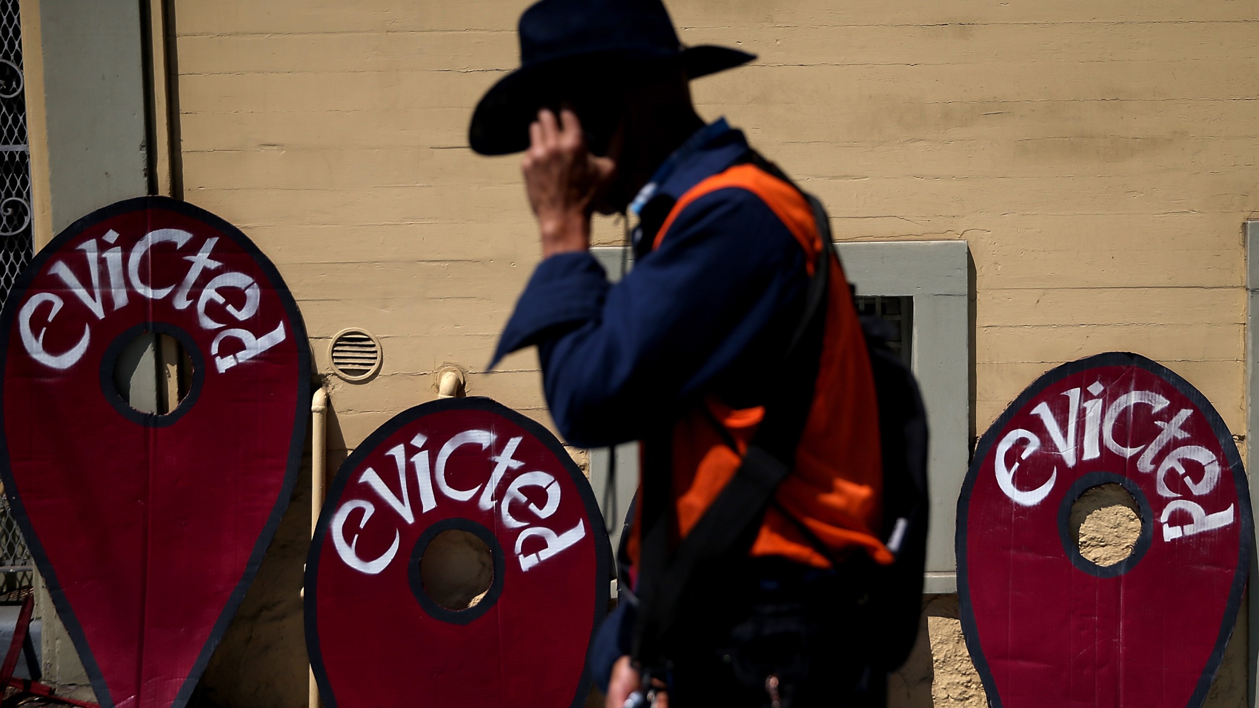 A protester walks in front of signs during a demonstration outside of an apartment building that allegedly evicted all tenants on July 29, 2014, in San Francisco. (Justin Sullivan/Getty Images)