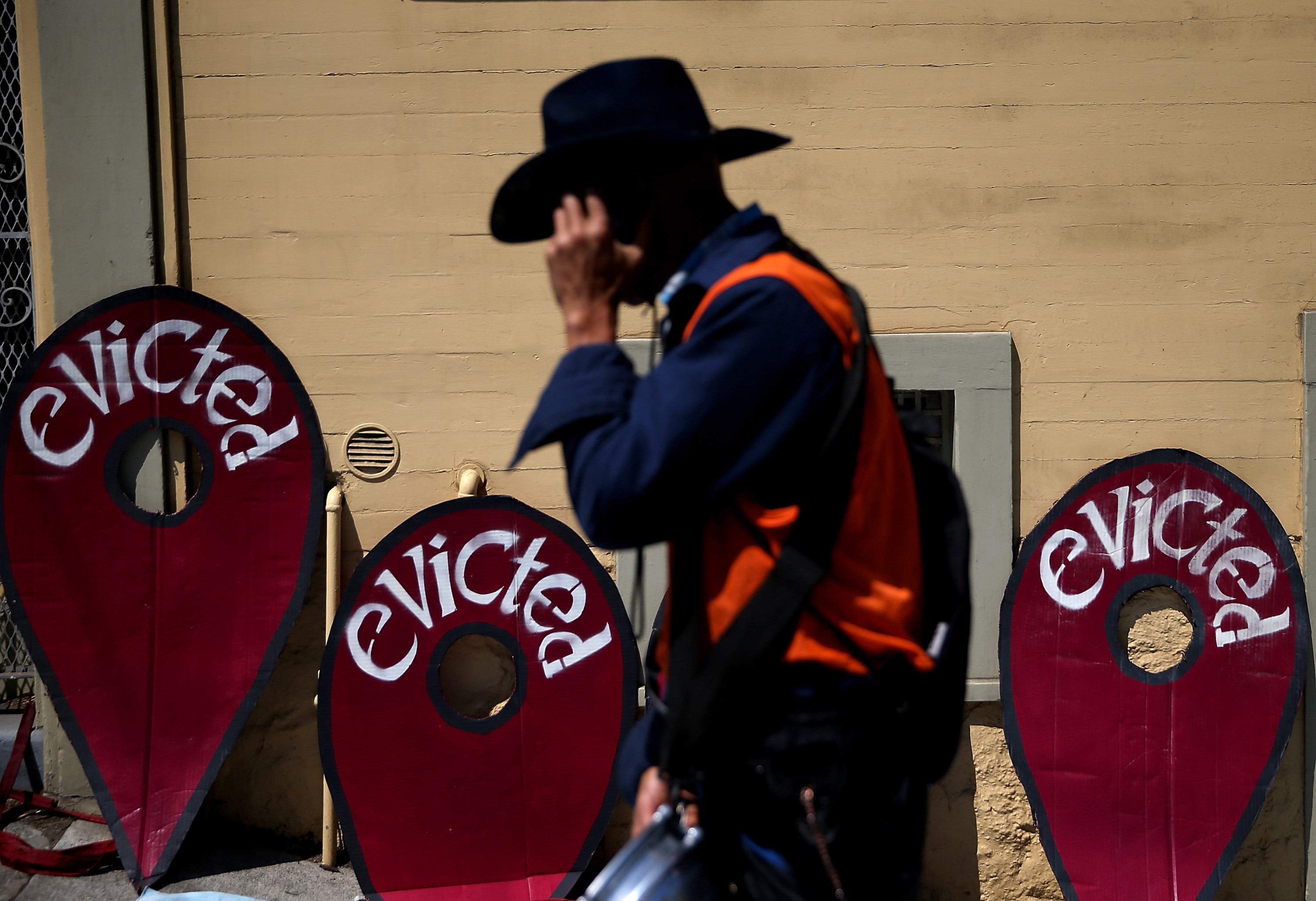 A protester walks in front of signs during a demonstration outside of an apartment building that allegedly evicted all tenants on July 29, 2014, in San Francisco. (Justin Sullivan/Getty Images)