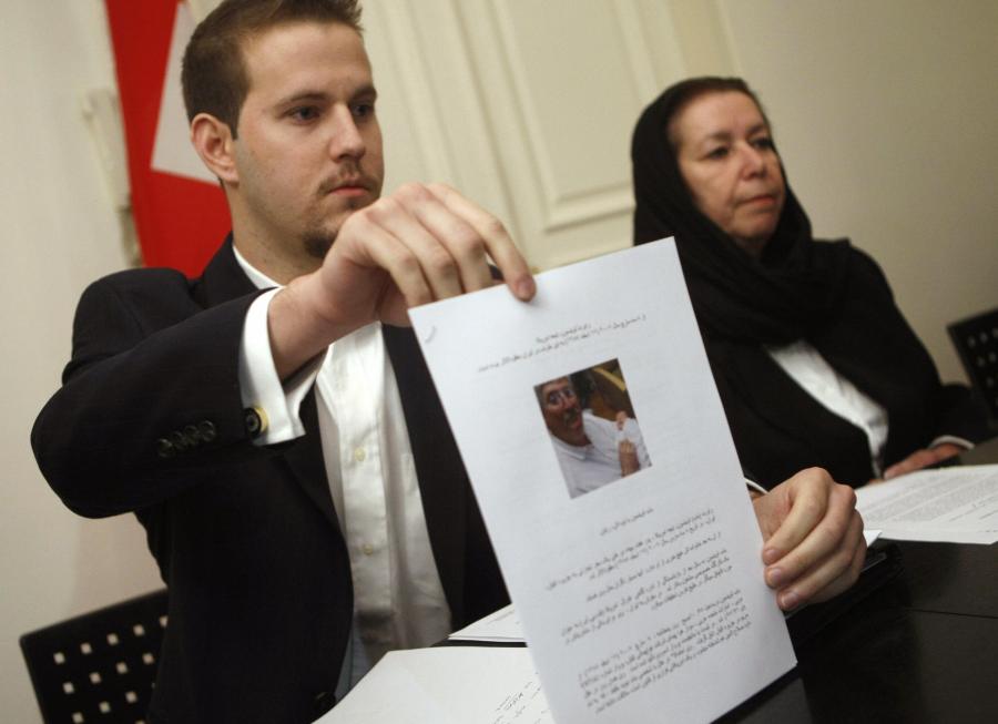 Daniel Levinson (left) shows a picture of his father, ex-FBI agent Robert Levinson, holding his grandson Ryan during a press conference with his mother Christine at the Swiss embassy in Tehran on Dec. 22 2007. (BEHROUZ MEHRI/AFP via Getty Images)