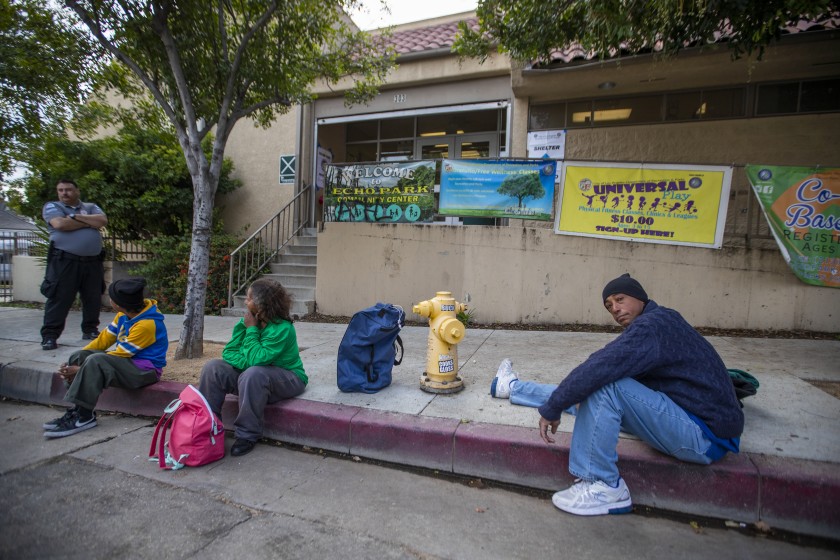 Tyrone Dixon, right, arrives with other people who are homeless at the Echo Park Community Center, one of several recreation centers being converted to shelters, on March 20, 2020. (Allen J. Schaben / Los Angeles Times)