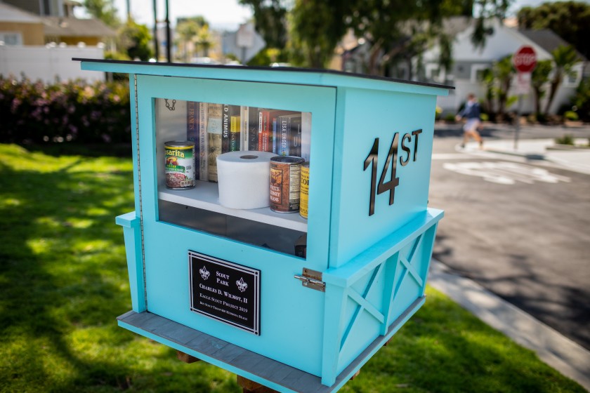 A lending library included some additional useful items, including a roll of toilet paper and cans of beans and corn, in a Hermosa Beach neighborhood on Sunday.(Jay L. Clendenin / Los Angeles Times)