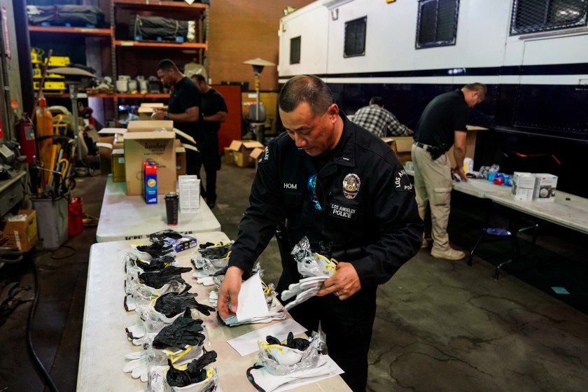 In March 2020, LAPD Lt. Jay Hom helps assemble kits consisting of an N95 mask, work gloves and nitrile gloves for field officers to protect themselves from exposure to the coronavirus. (Kent Nishimura / Los Angeles Times)