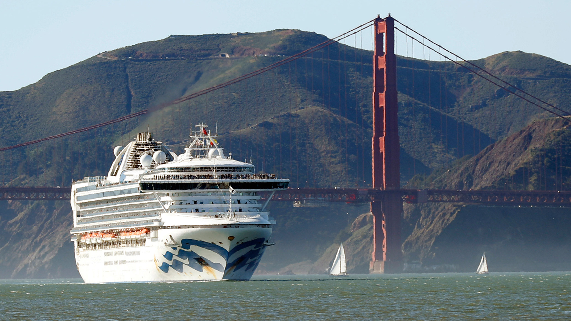 In this Feb. 11, 2020 photo, the Grand Princess cruise ship passes the Golden Gate Bridge as it arrives from Hawaii in San Francisco. California's first coronavirus fatality is an elderly patient who apparently contracted the illness on a cruise, authorities said Wednesday, March 4, and a medical screener at Los Angeles International Airport is one of six new confirmed cases. The cruise ship is at sea but is expected to skip its next port and return to San Francisco by Thursday, according to a statement from Dr. Grant Tarling, the chief medical officer for the Carnival Corp., which operates the Grand Princess. Any current passengers who were also on the February trip will be screened. (Scott Strazzante/San Francisco Chronicle via AP)