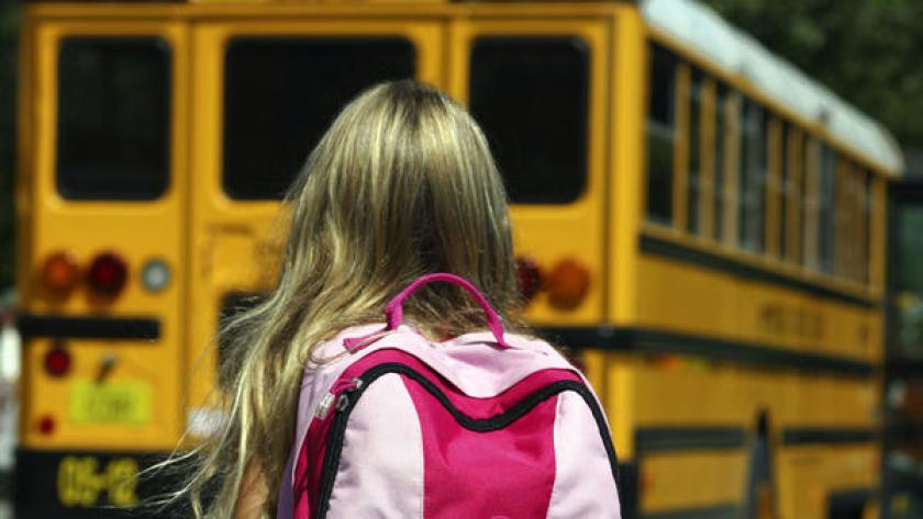 A child is seen near a school bus in this undated photo. (Los Angeles Times)