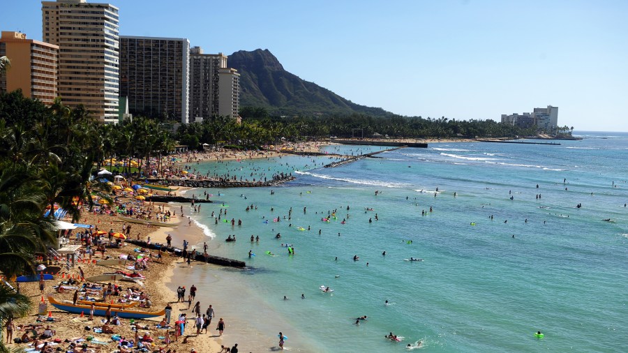 Tourists enjoy sunbathing, surfing, boating and swimming at Waikiki beach in Honolulu, Hawaii, on Jan. 1, 2010. (JEWEL SAMAD/AFP via Getty Images)