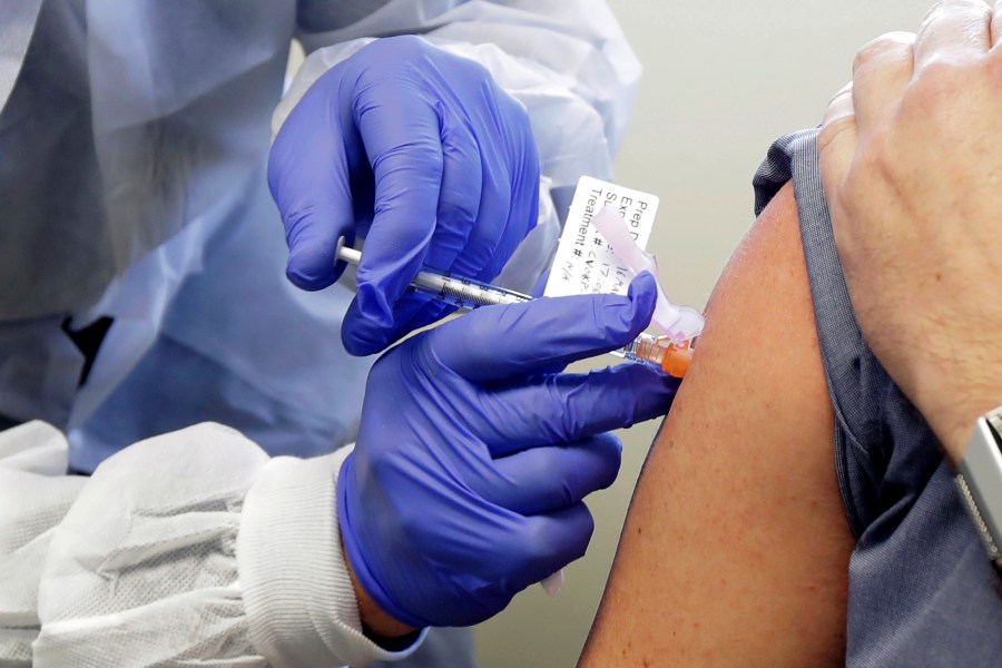 Neal Browning receives a shot in the first-stage safety study clinical trial of a potential vaccine for COVID-19, the disease caused by the new coronavirus, Monday, March 16, 2020, at the Kaiser Permanente Washington Health Research Institute in Seattle. Browning is the second patient to receive the shot in the study. (AP Photo/Ted S. Warren)