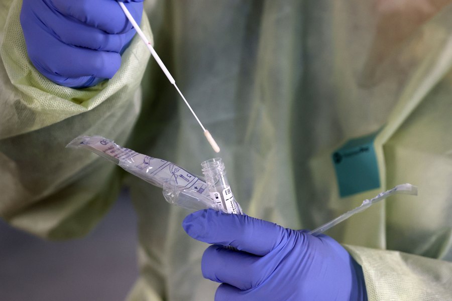 Dawn Canova, clinical manager for outpatient wound care at Carroll Hospital, handles a sample from a person tested for the coronavirus at a drive-thru station in the hospital's parking garage March 16, 2020 in Westminster, Maryland. (Chip Somodevilla/Getty Images)