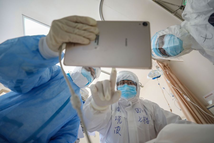 This photo taken on February 16, 2020 shows a doctor looking at an image as he checks a patient who is infected by the COVID-19 coronavirus at the Wuhan Red Cross Hospital in Wuhan in China's central Hubei province. (STR/AFP via Getty Images)