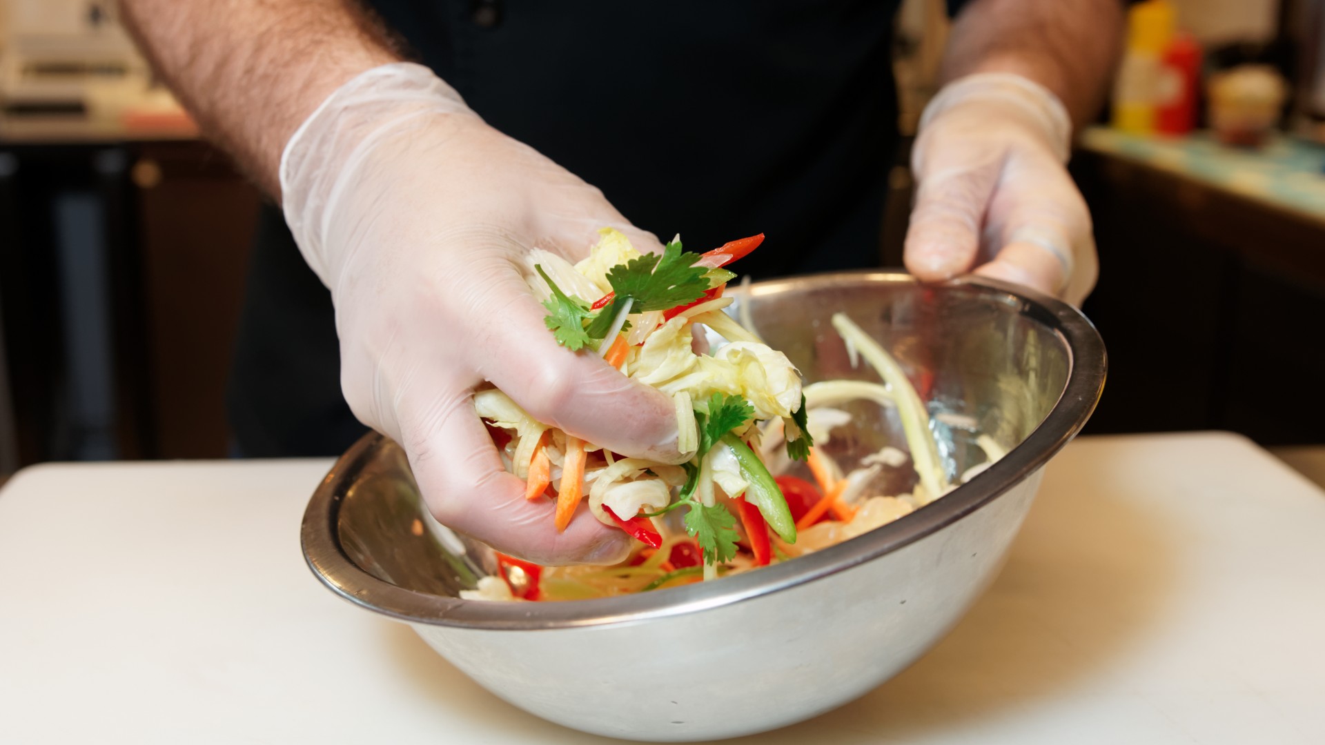 A worker wearing gloves mixes a salad in this file photo. (Getty images)