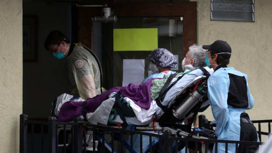 Emergency medical technicians with Royal Ambulance move a patient on a gurney from an ambulance into the Gateway Care and Rehabilitation Center on April 16, 2020 in Hayward, California. (Justin Sullivan/Getty Images)