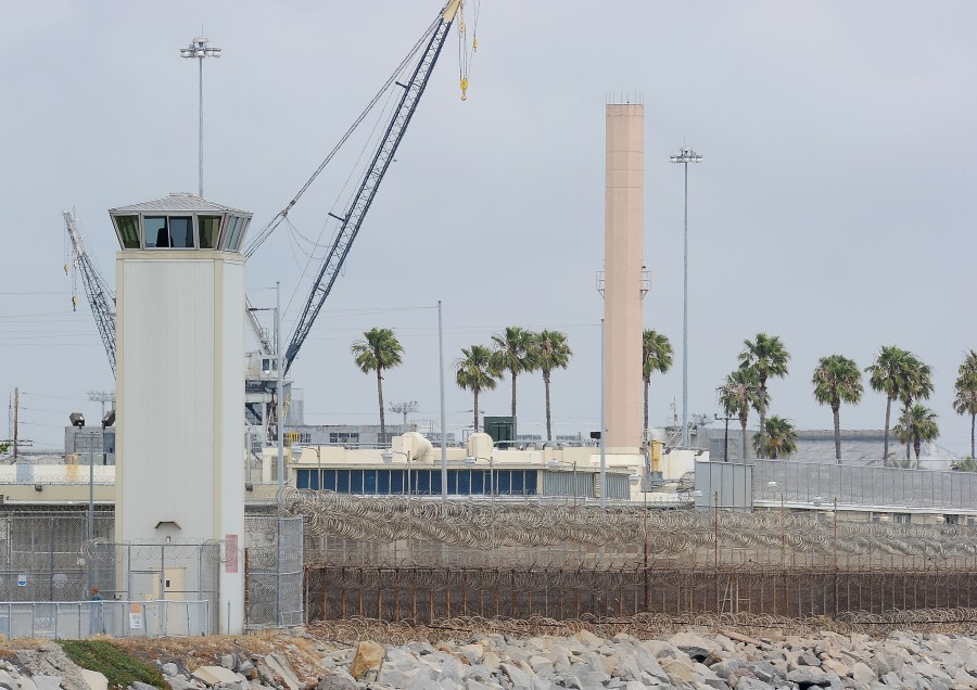 Shipping cranes are visible behind a watchtower of Terminal Island Federal prision on May 27, 2010, off the coast of Los Angeles and Long Beach. (ROBYN BECK/AFP via Getty Images)