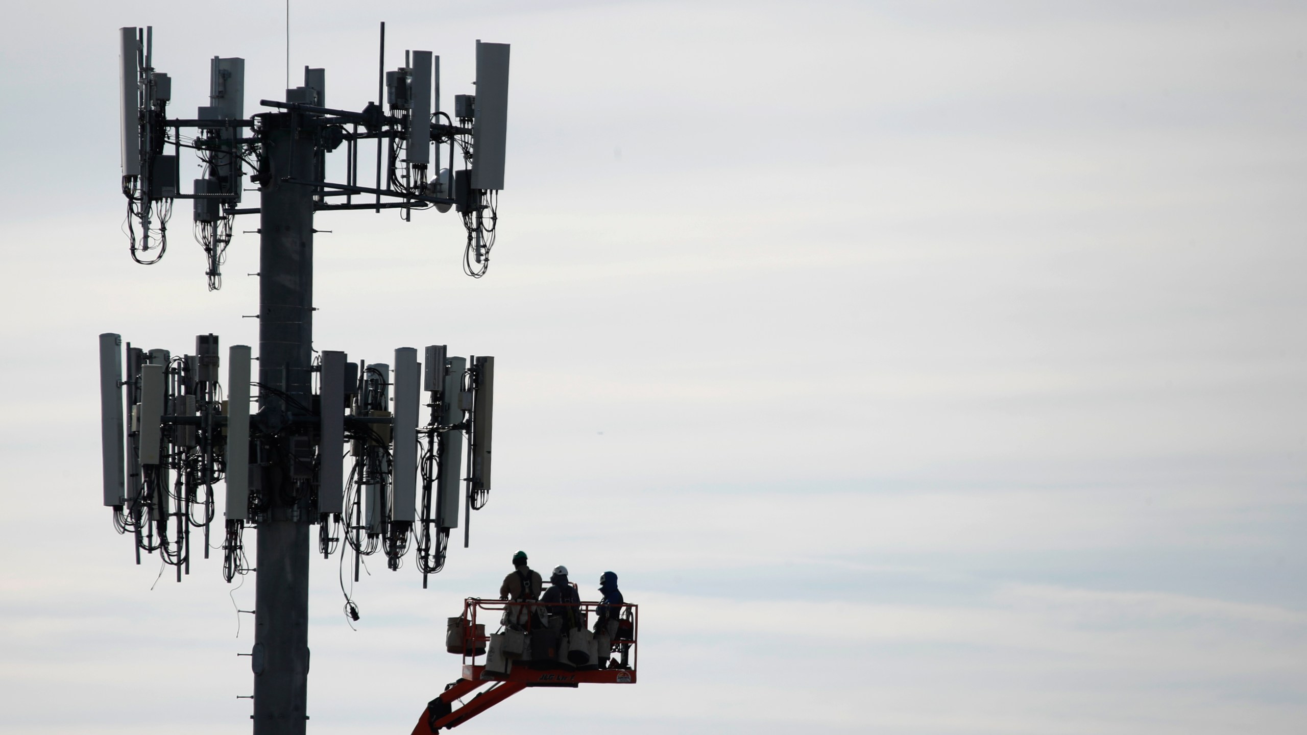 A file photo shows a crew working on a cell tower to update it to handle the 5G network. (GEORGE FREY/AFP via Getty Images)