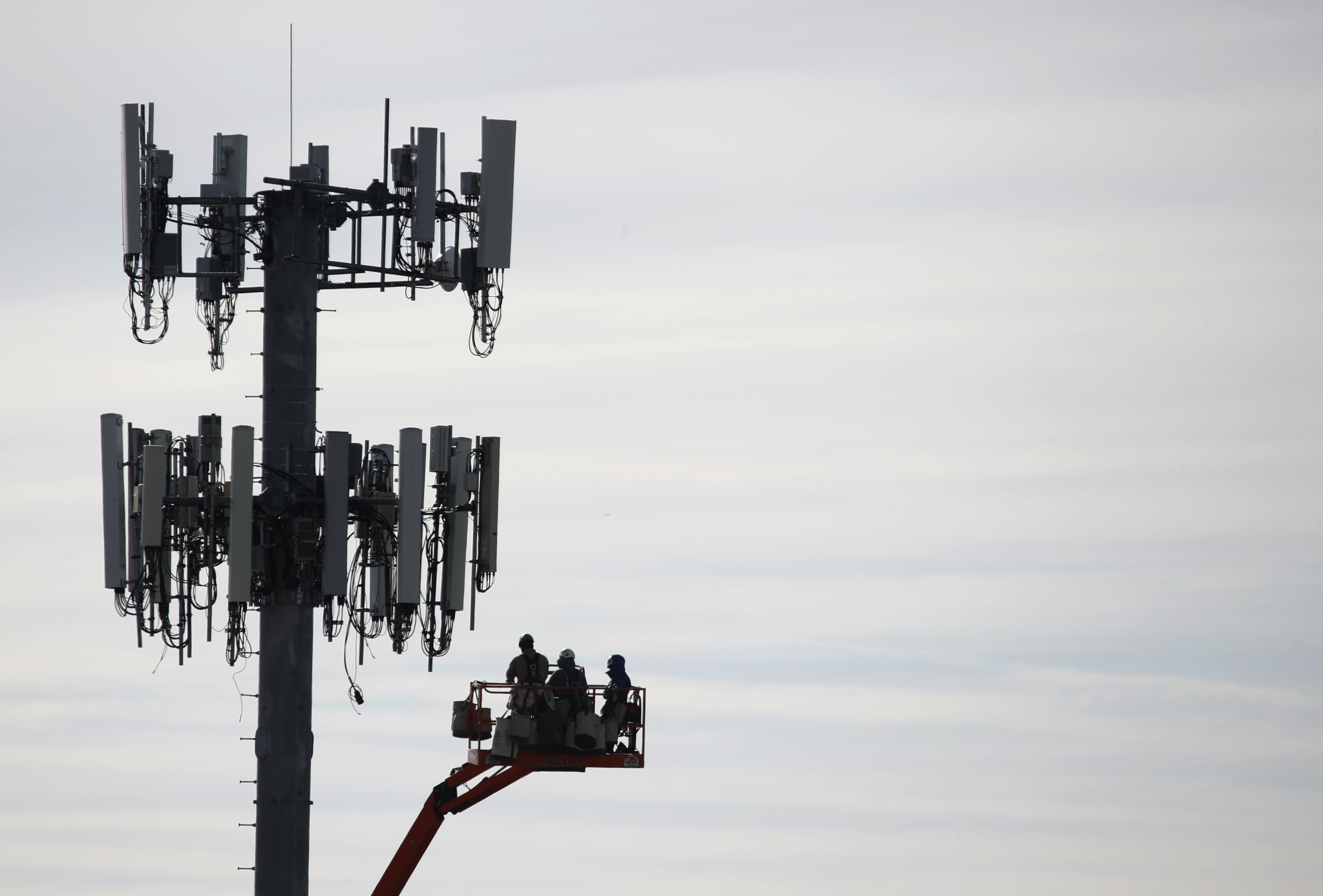 A file photo shows a crew working on a cell tower to update it to handle the 5G network. (GEORGE FREY/AFP via Getty Images)