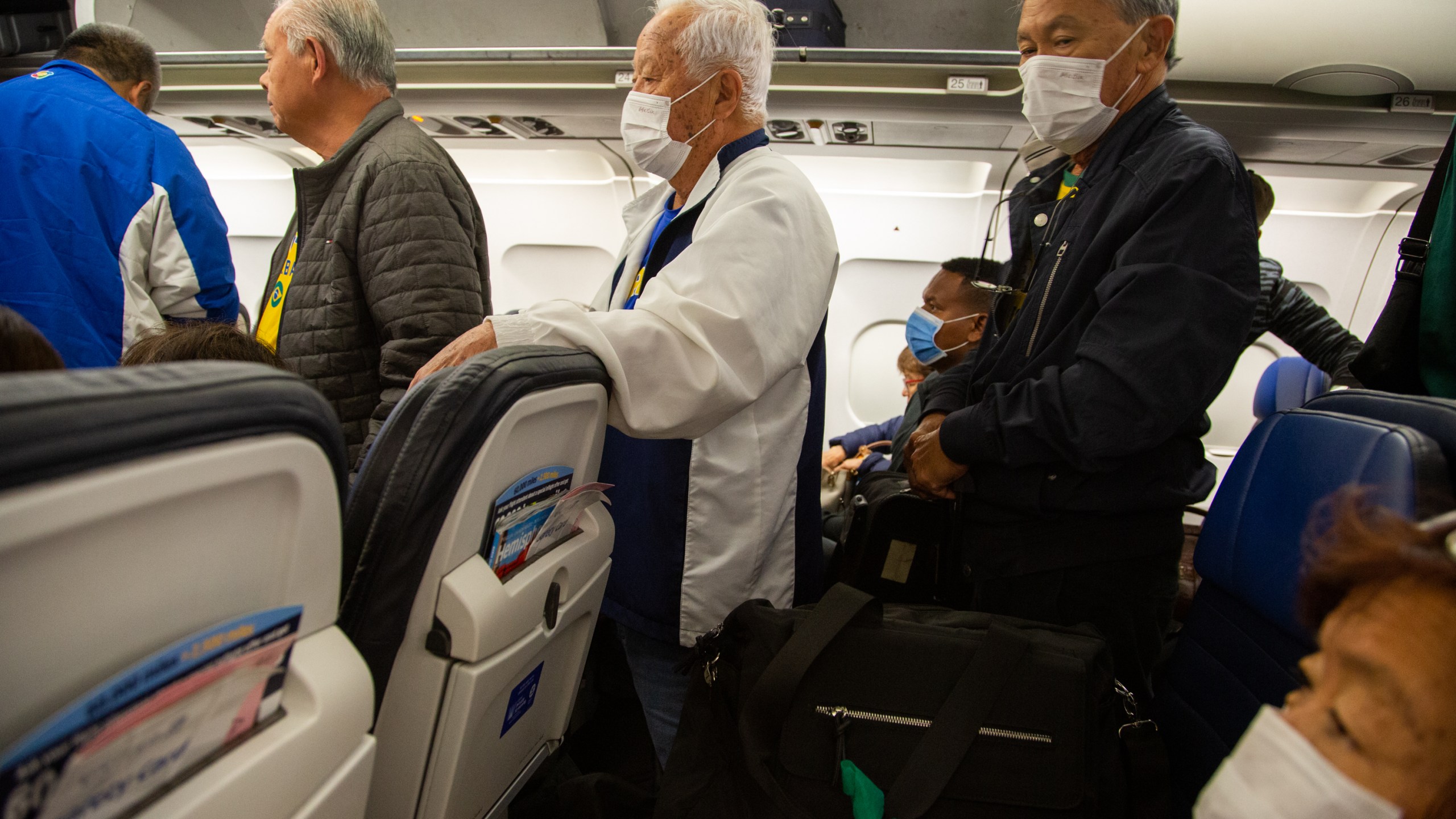 Passengers wear protective face masks in a airplane after arrival in Houston International Airport on March 14, 2020 in Houston, Texas (Carol Coelho/Getty Images)