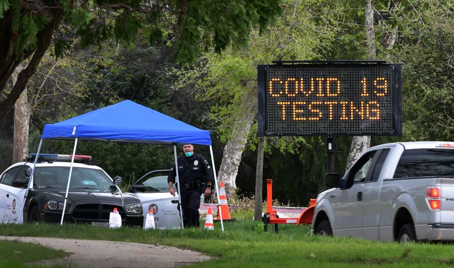 A police officer mans the entrance to a coronavirus (COVID-19) testing center in Hansen Dam Park on March 25, 2020 in Pacoima. (FREDERIC J. BROWN/AFP via Getty Images)