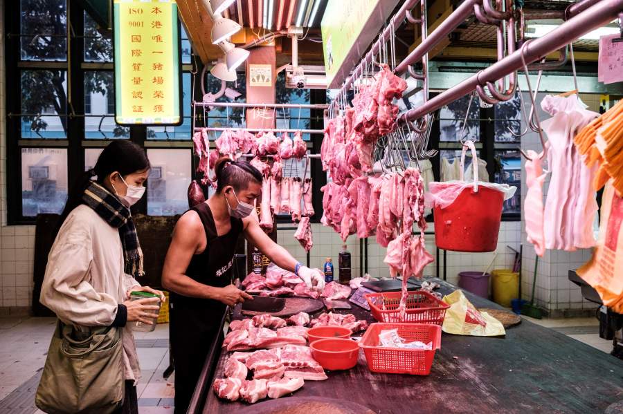 In this picture taken in Hong Kong on March 18, 2020, Mandy Tang, who used to be an interior designer and is now a housewife, buys locally farmed pork from a butcher at a market.(ANTHONY WALLACE/AFP via Getty Images)