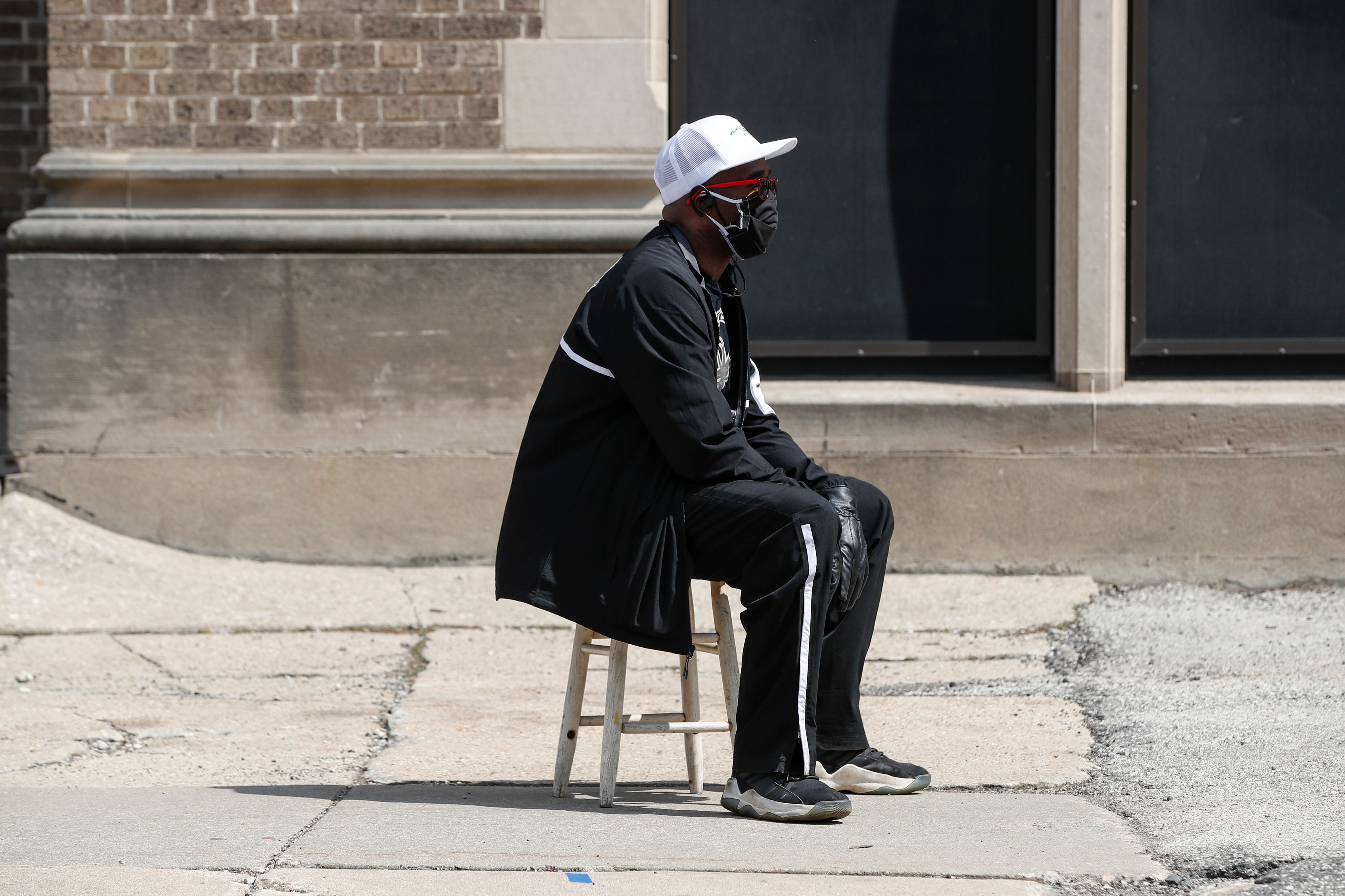 A man waits in long line to vote in a presidential primary election outside the Riverside High School in Milwaukee, Wisconsin, on April 7, 2020. (KAMIL KRZACZYNSKI/AFP via Getty Images)