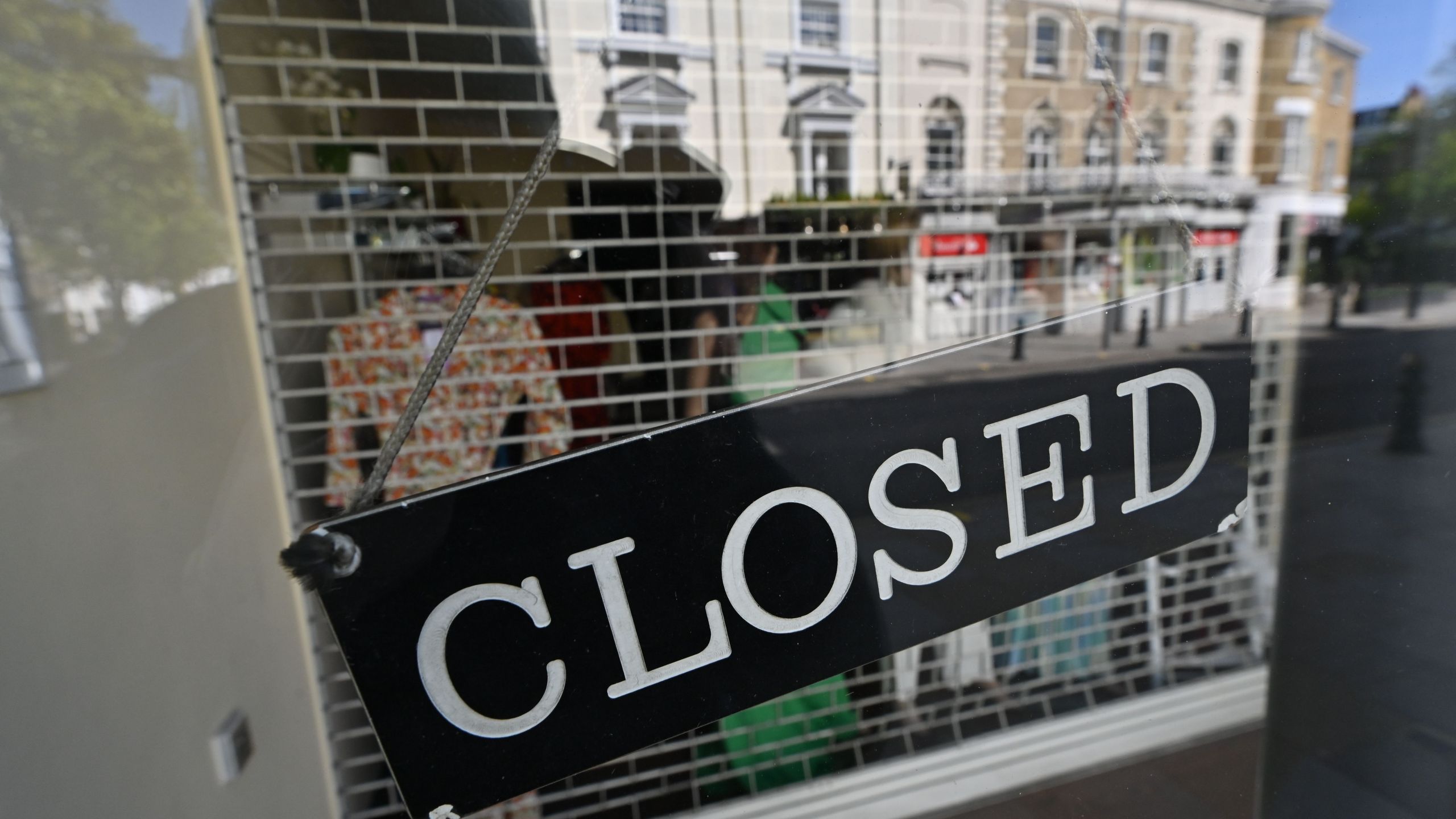 A closed sign is seen on the front of a closed clothing store in this file photo on April 14, 2020. (JUSTIN TALLIS/AFP via Getty Images)