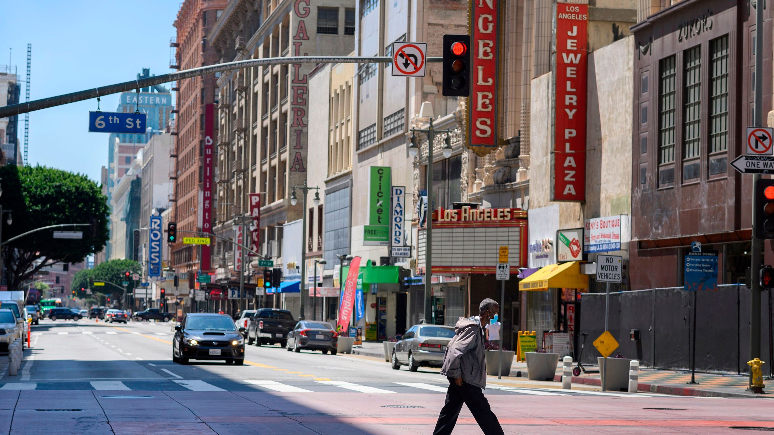 A pedestrian crosses a street in downtown Los Angeles during the coronavirus pandemic on April 14, 2020. (Credit: Robyn Beck / AFP / Getty Images)