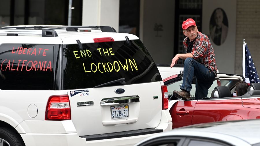 A man looks on as hundreds of people gather to protest the lockdown in spite of stay-at-home rules still being in effect at California's state capitol building in Sacramento on April 20, 2020. (JOSH EDELSON/AFP via Getty Images)