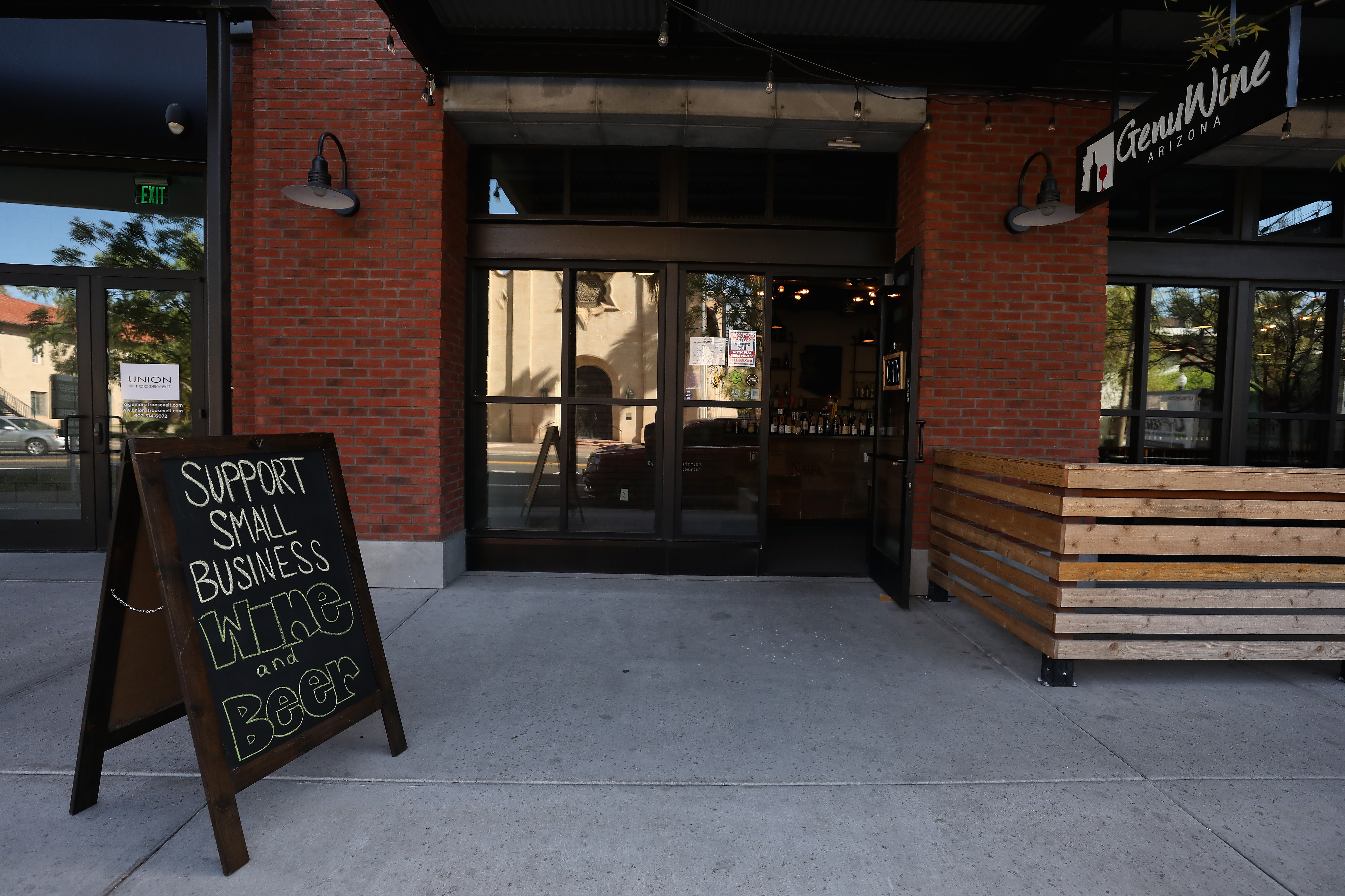 A sign reading "Support Small Business" is displayed outside of GenuWine Arizona restaurant on March 26, 2020, in Phoenix, Arizona. (Christian Petersen/Getty Images)