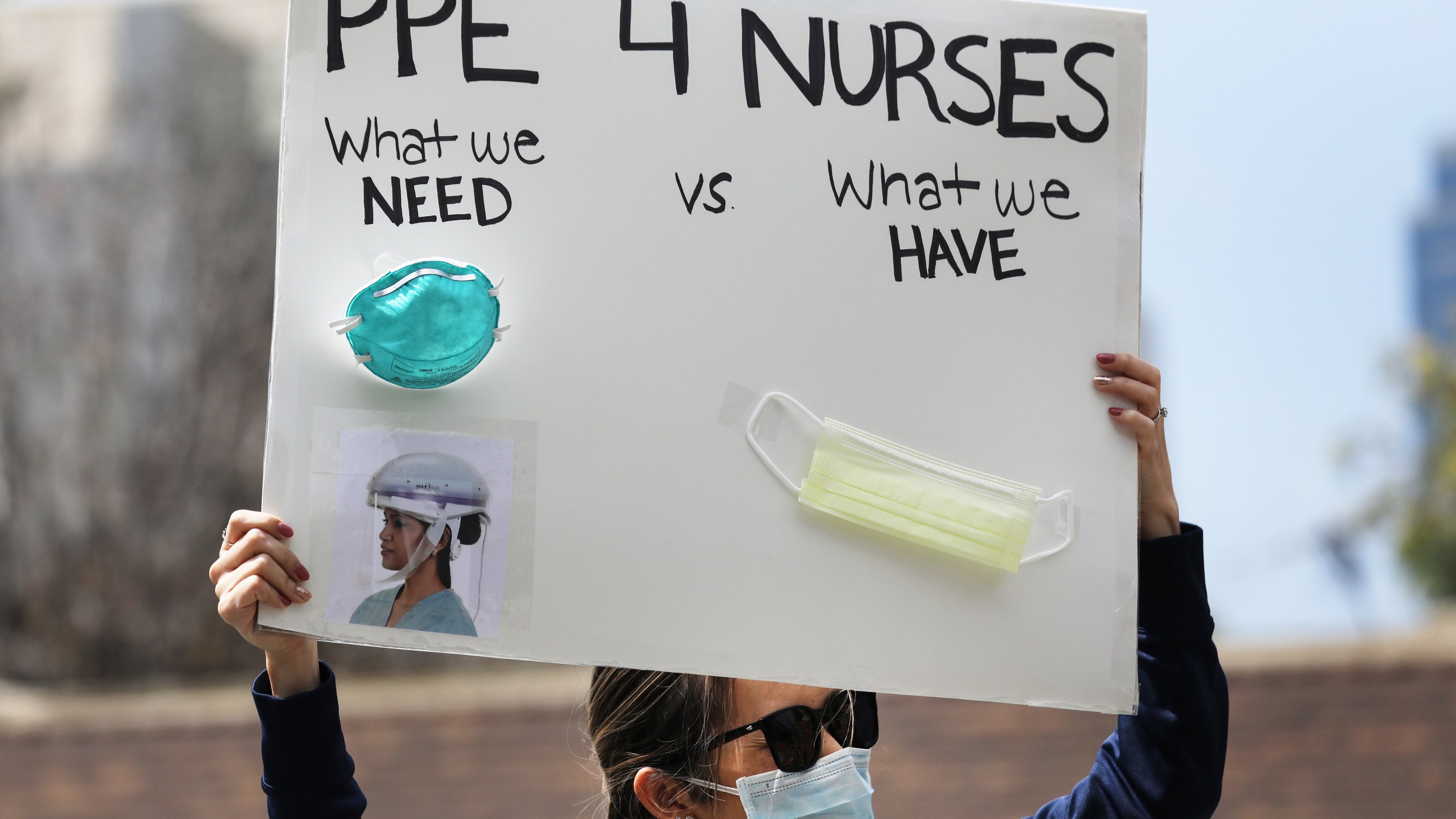 A nurse holds up a sign to protest the lack of personal protective gear available at UCI Medical Center amid the coronavirus pandemic on April 3, 2020 in Orange. (Mario Tama / Getty Images)