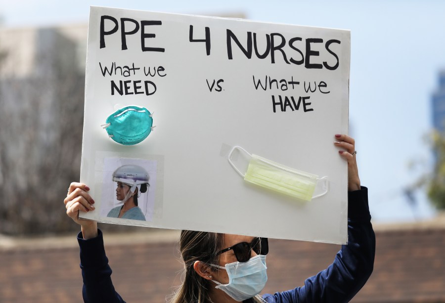 A nurse holds up a sign to protest the lack of personal protective gear available at UCI Medical Center amid the coronavirus pandemic on April 3, 2020 in Orange. (Mario Tama / Getty Images)