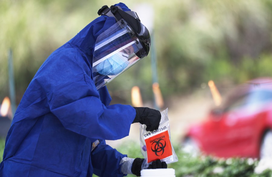 A volunteer holds a specimen bag at a drive-through coronavirus testing site outside Malibu City Hall on April 8, 2020. (Mario Tama/Getty Images)