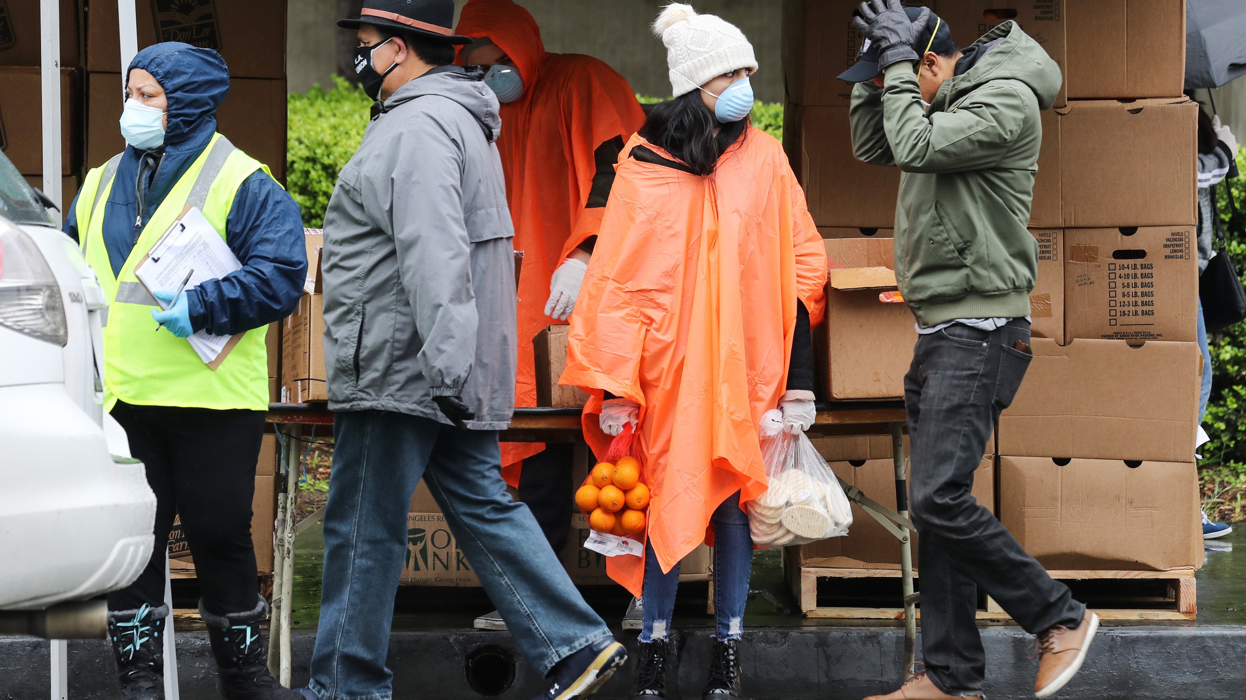 A volunteer holds food to be distributed to a family at a Los Angeles Regional Food Bank distribution for those in need as the coronavirus pandemic continues on April 9, 2020 in Van Nuys. (Mario Tama/Getty Images)