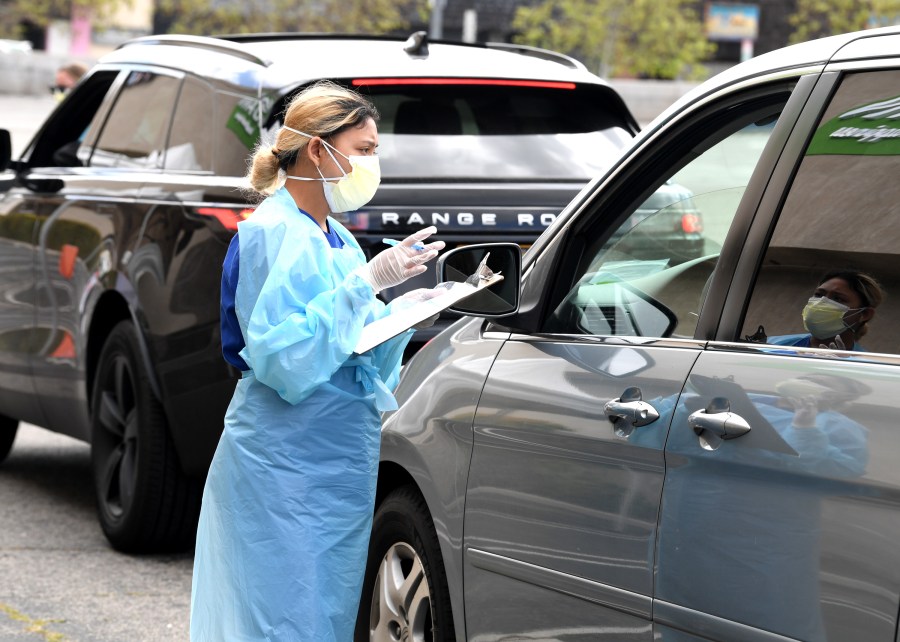 A worker gathers specimens at a drive-thru COVID-19 testing site at the Westfield Fashion Square in Sherman Oaks on April 13, 2020. (Credit: Kevin Winter / Getty Images)