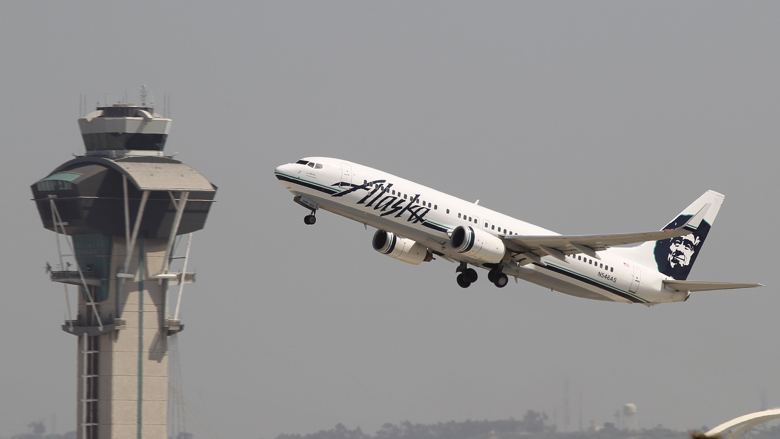 An Alaska Airlines jet passes the air traffic control tower at Los Angeles International Airport (LAX) in this April 22, 2013 file photo. (David McNew/Getty Images)