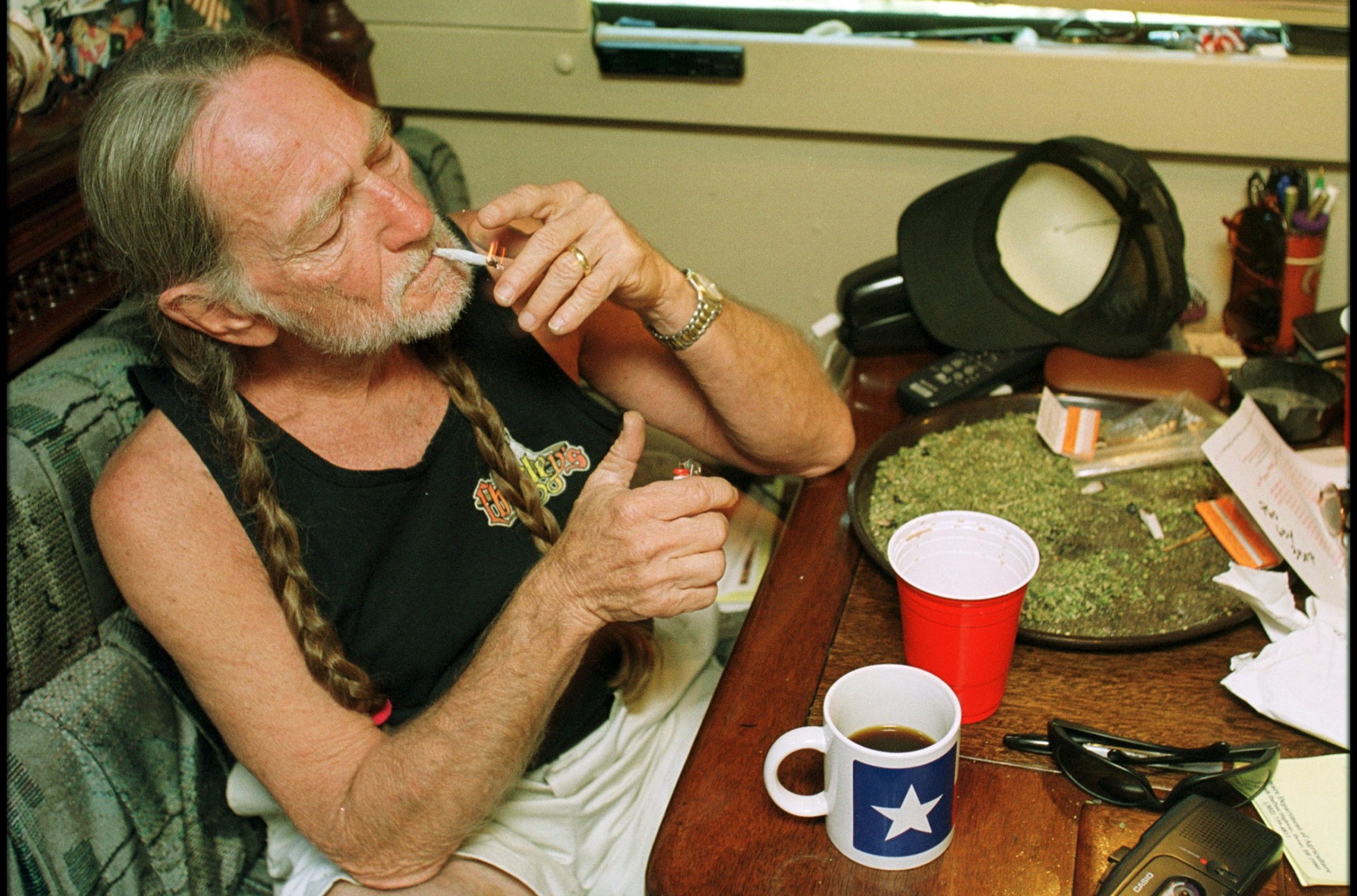 American country singer Willie Nelson takes a drag off a joint while relaxing at his home in Texas during the early 2000s. (Liaison/Getty Images)