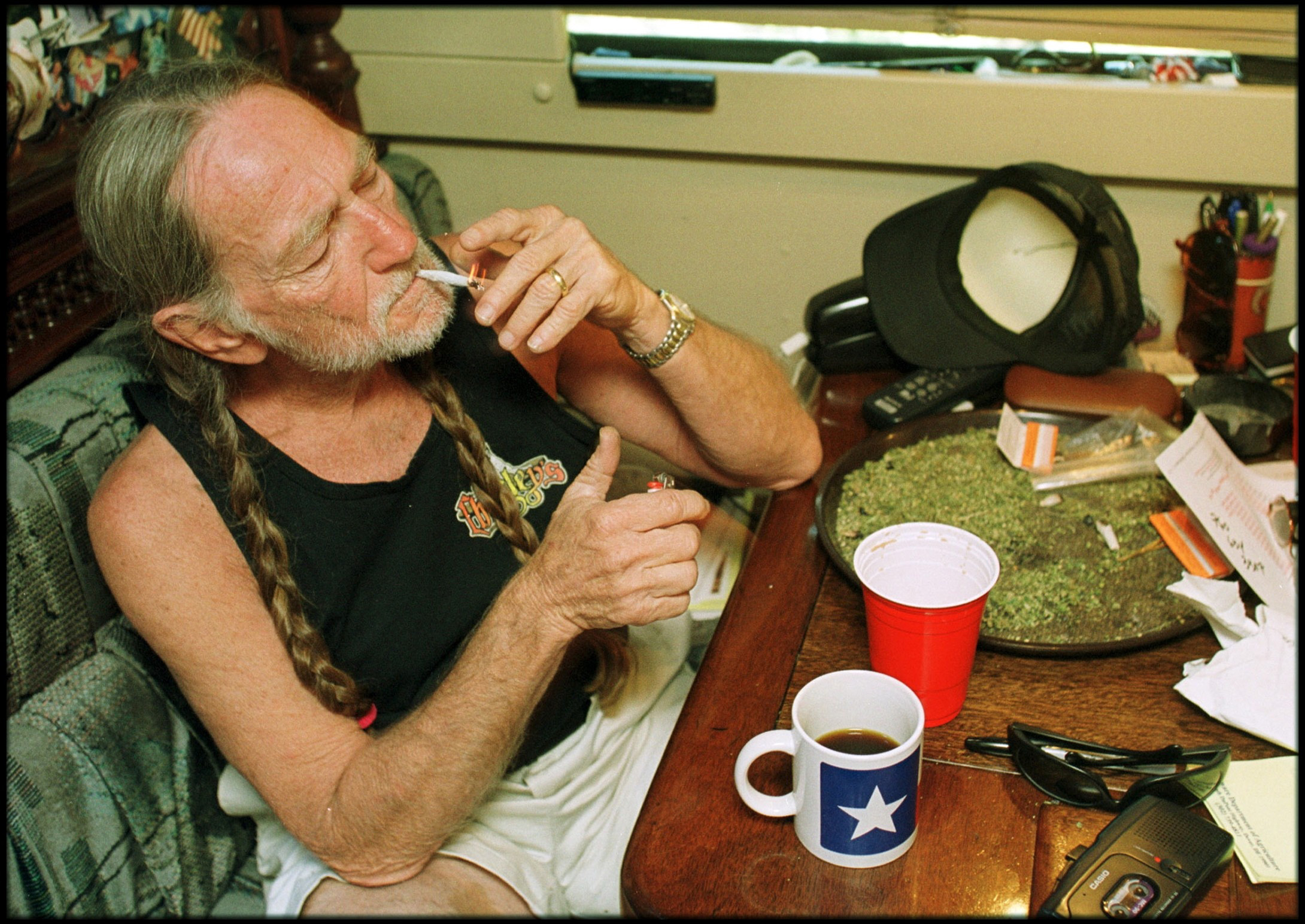 American country singer Willie Nelson takes a drag off a joint while relaxing at his home in Texas during the early 2000s. (Liaison/Getty Images)