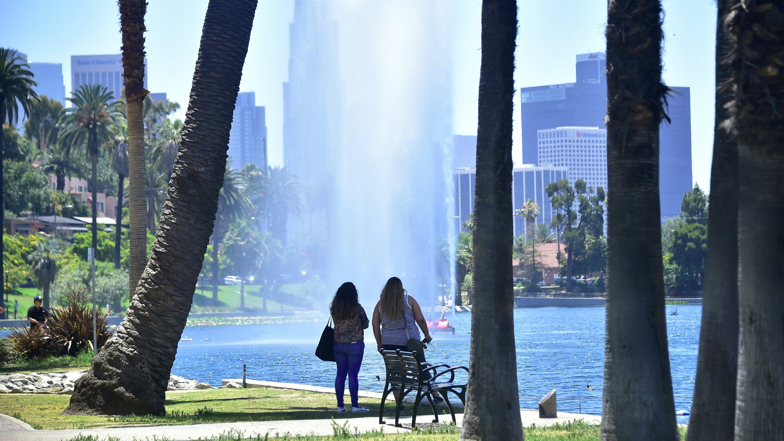 Women cool off with a view of a fountain and sprinkles of water blowing in the breeze at Echo Park Lake on June 26, 2017. (Frederic J. Brown /AFP / Getty Images)