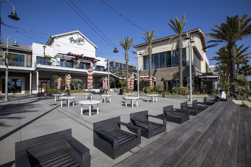 Daniel Guzman, right, an unemployed pool supervisor from Garden Grove, sits alone in the mostly closed and normally crowded Pacific City shopping mall in Huntington Beach.(Allen J. Schaben / Los Angeles Times)