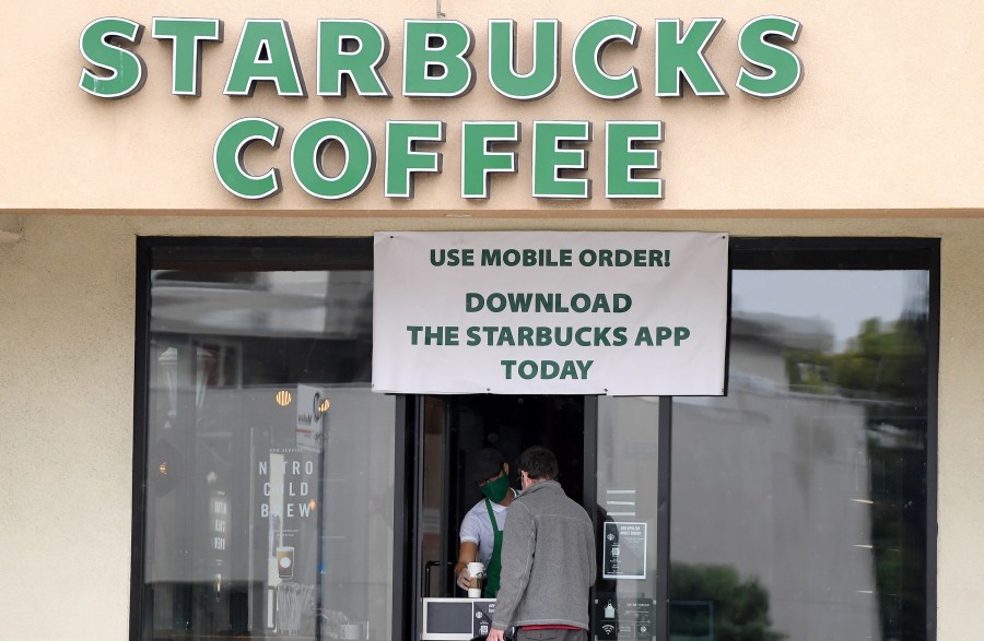 A Starbucks employee serves a walk-up customer amid the ongoing coronavirus pandemic on April 07, 2020 in South Pasadena. (Harry How/Getty Images)