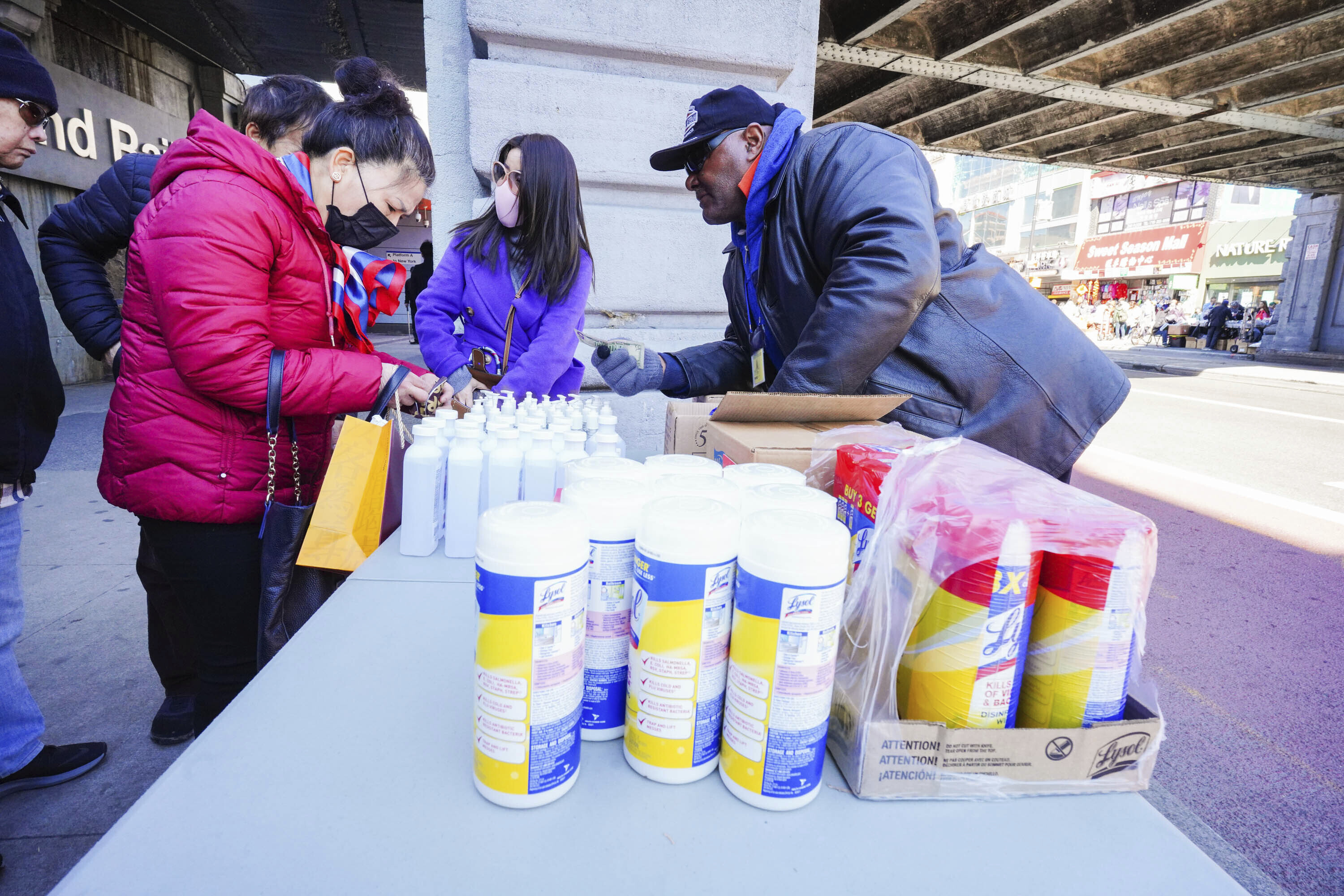 People wear protective masks to fend off the Coronavirus, while street vendors pedal masks, hand sanitizer and other disinfecting products in Queens, New York. (John Nacion/STAR MAX/IPx/AP)