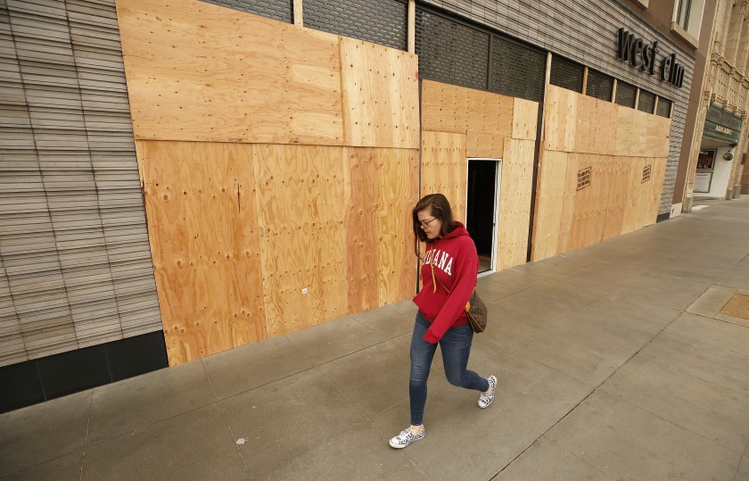 Elena Girotto walks past the boarded-up West Elm store on Colorado Boulevard in Pasadena on April 2, 2020. (Al Seib/Los Angeles Times)