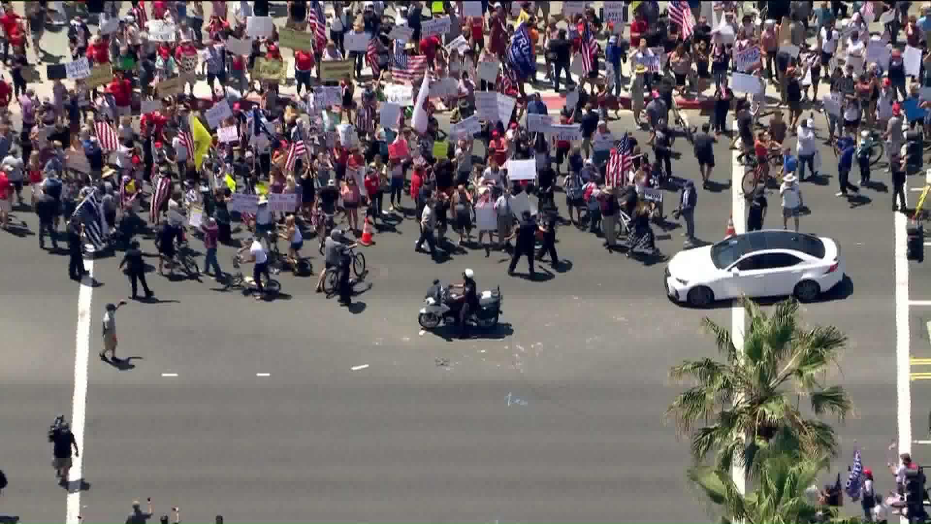 Protestors gather in Huntington Beach on May 1, 2020, after state's order to close Orange County beaches. (KTLA)