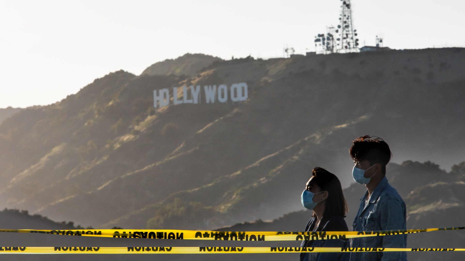 People wearing facemasks walk at the Griffith Observatory with a view of the Hollywood sign at the start of Memorial Day holiday weekend amid the novel coronavirus pandemic in Los Angeles on May 22, 2020. (Apu Gomes/Getty Images)