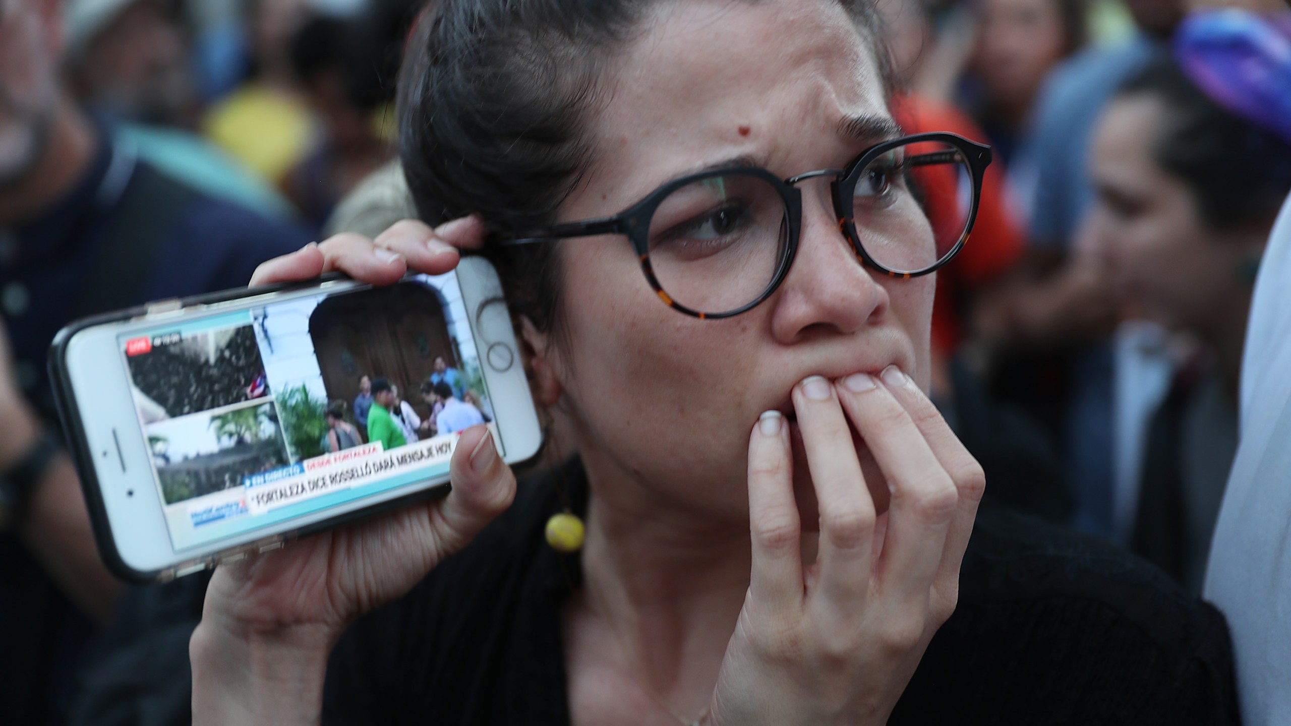 Protesters listen to a broadcast from inside the governor's mansion on their mobile phones as expectations remained high that Gov. Ricardo Rosselló would step down on July 24, 2019 in Old San Juan, Puerto Rico. (Joe Raedle/Getty Images)