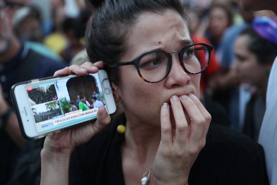 Protesters listen to a broadcast from inside the governor's mansion on their mobile phones as expectations remained high that Gov. Ricardo Rosselló would step down on July 24, 2019 in Old San Juan, Puerto Rico. (Joe Raedle/Getty Images)