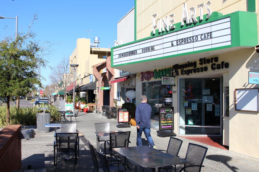 A man glances into ZombieRunner coffee shop as he strides along a quiet sidewalk in downtown Palo Alto, amid the coronavirus crisis on March 12, 2020. (GLENN CHAPMAN/AFP via Getty Images)