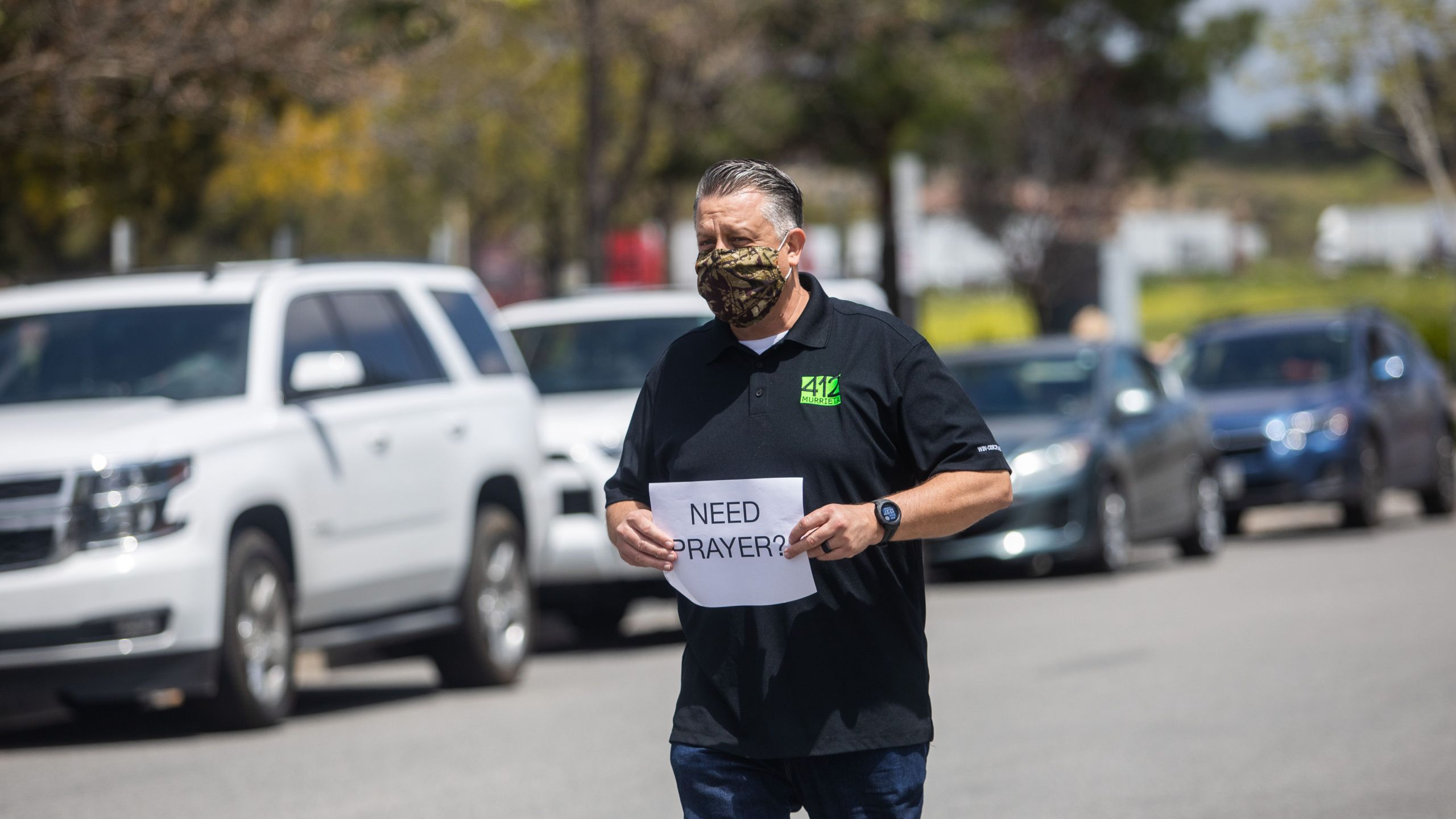 Simon Cooper offers prayers to people who attended an online Sunday Service inside their cars at the Christian '412 Church Murrieta' parking lot on April 19, 2020, in Murrieta, California. (APU GOMES/AFP via Getty Images)